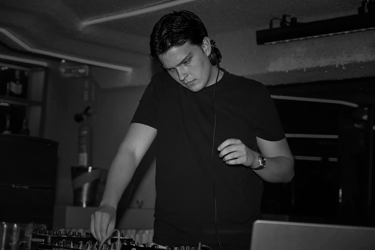 A DJ working the decks in the ONHOUSE booth, black and white